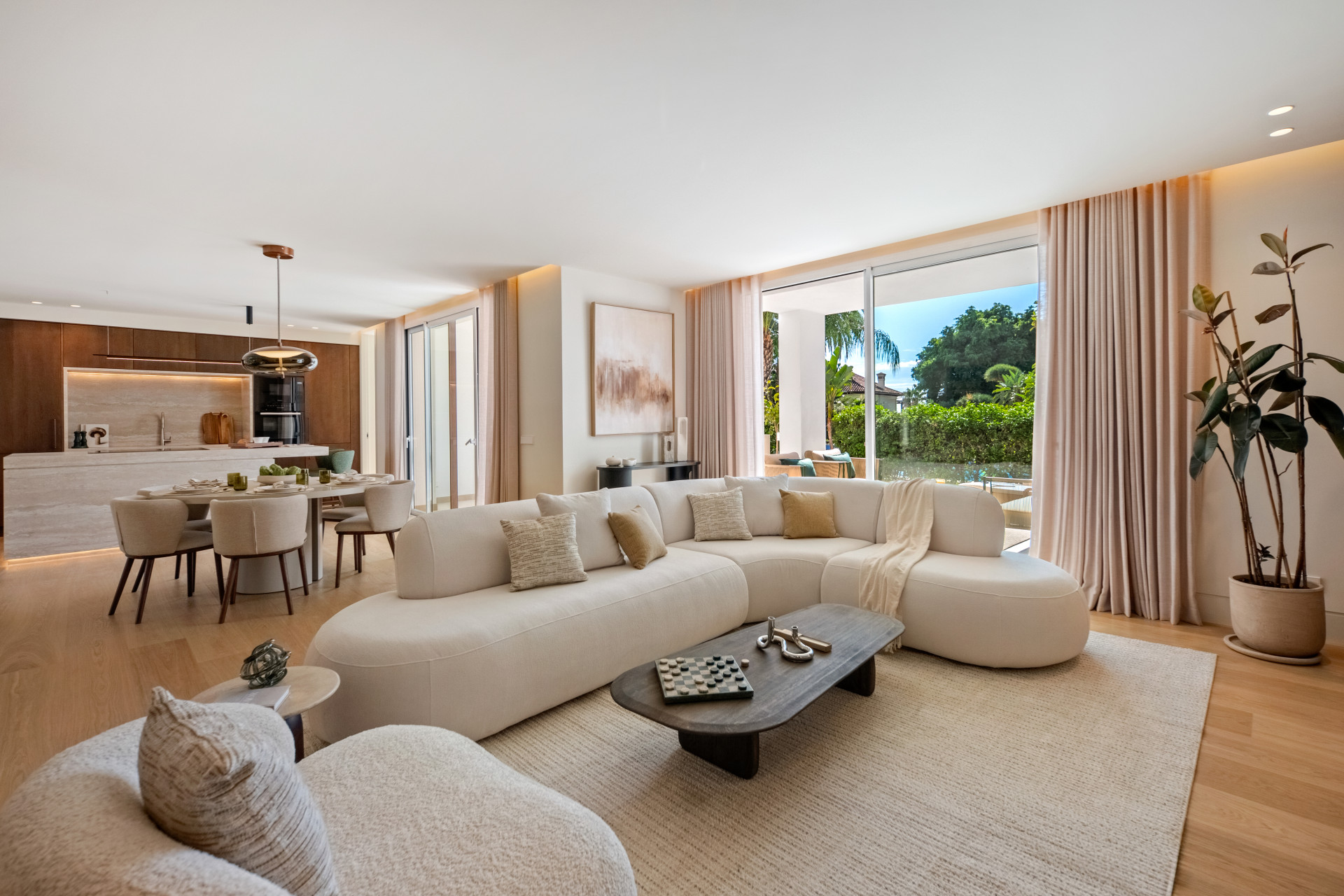 Cream curved seating and oak flooring beside the dining area and garden-facing glazing.