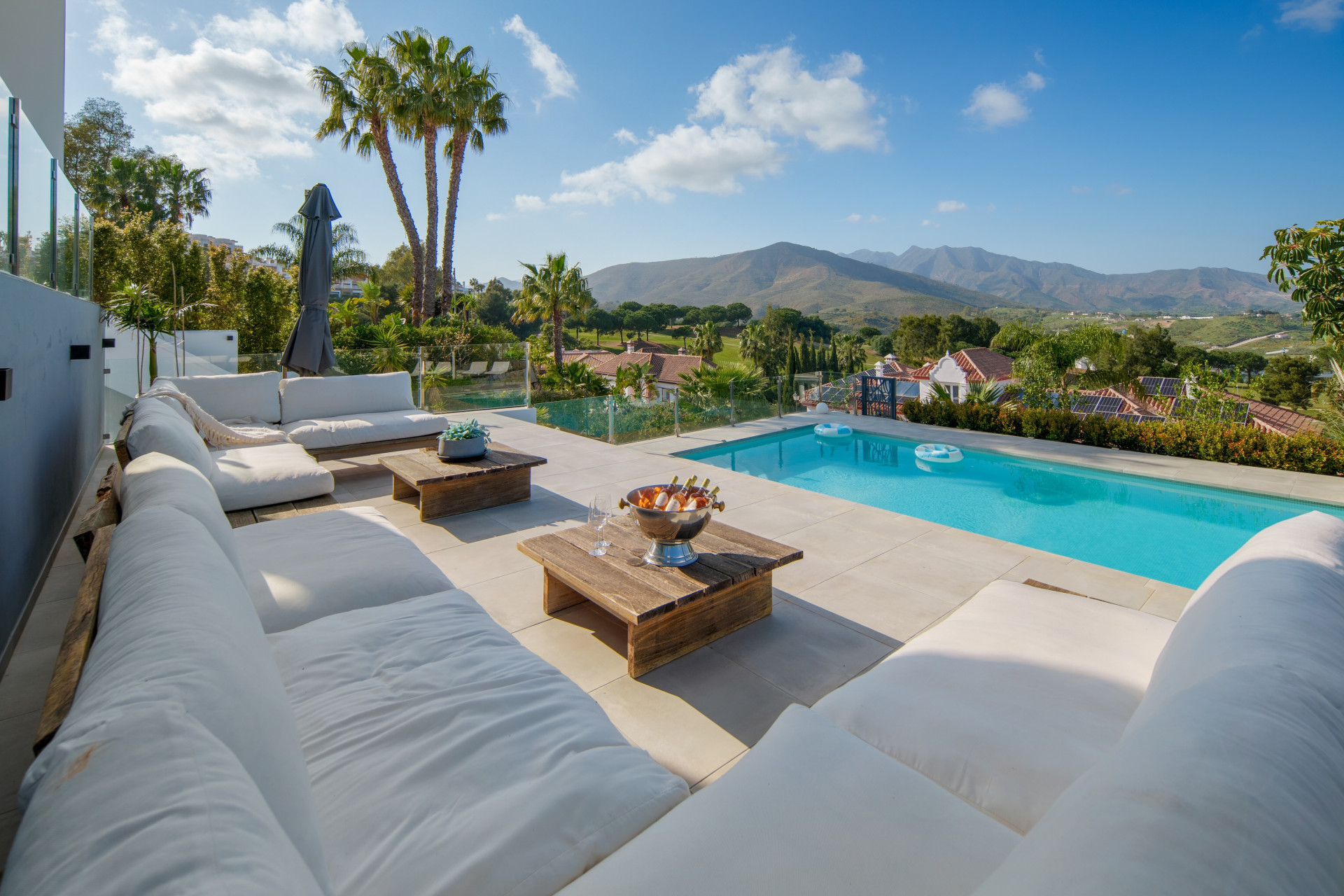Poolside seating and palm trees facing the hills at La Cala Golf