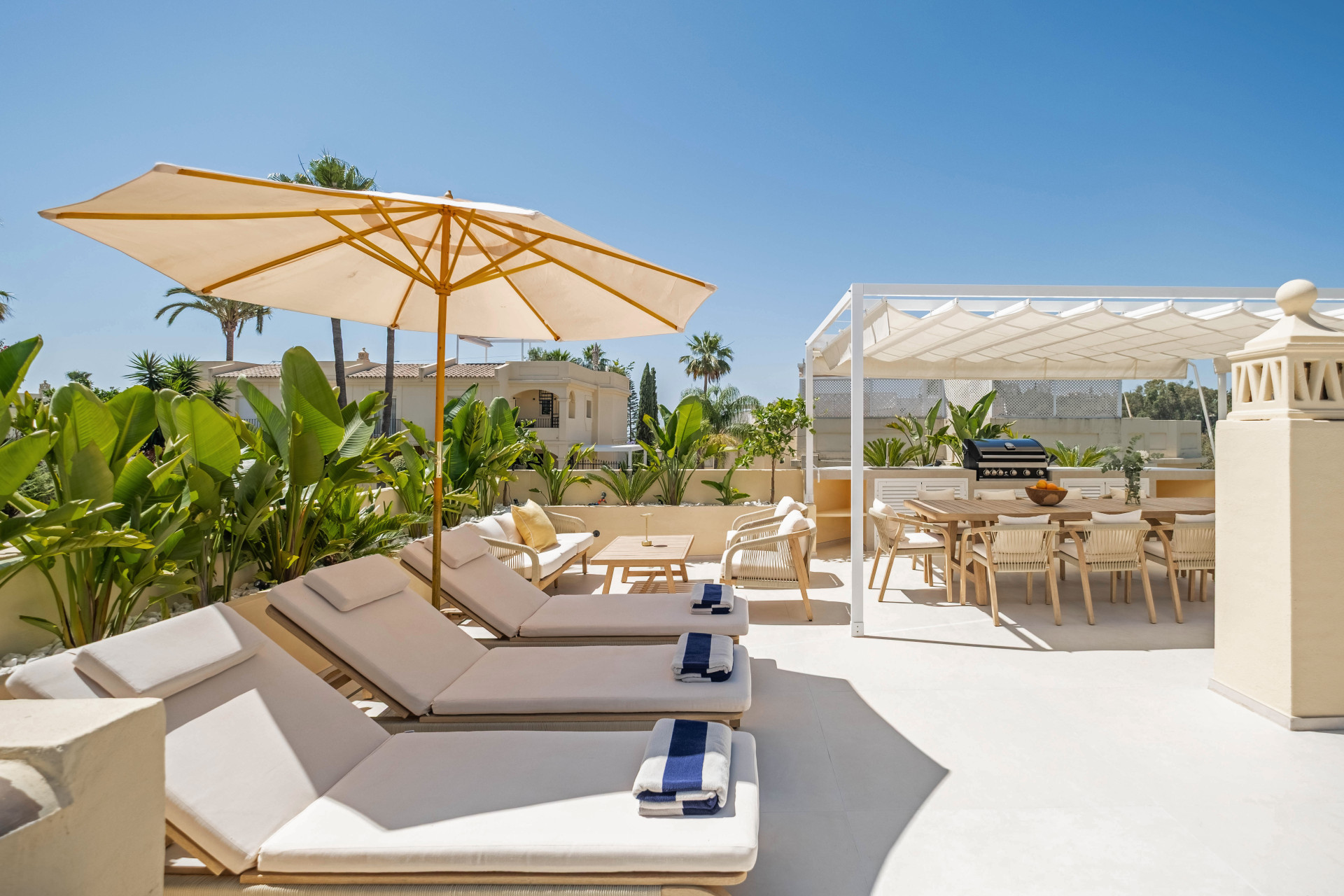 Sun loungers and a pergola-covered dining terrace at the La Quinta corner home.