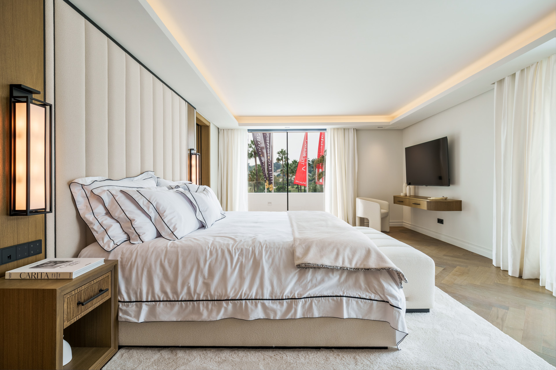 Bedroom with pale textiles and glazing towards the garden