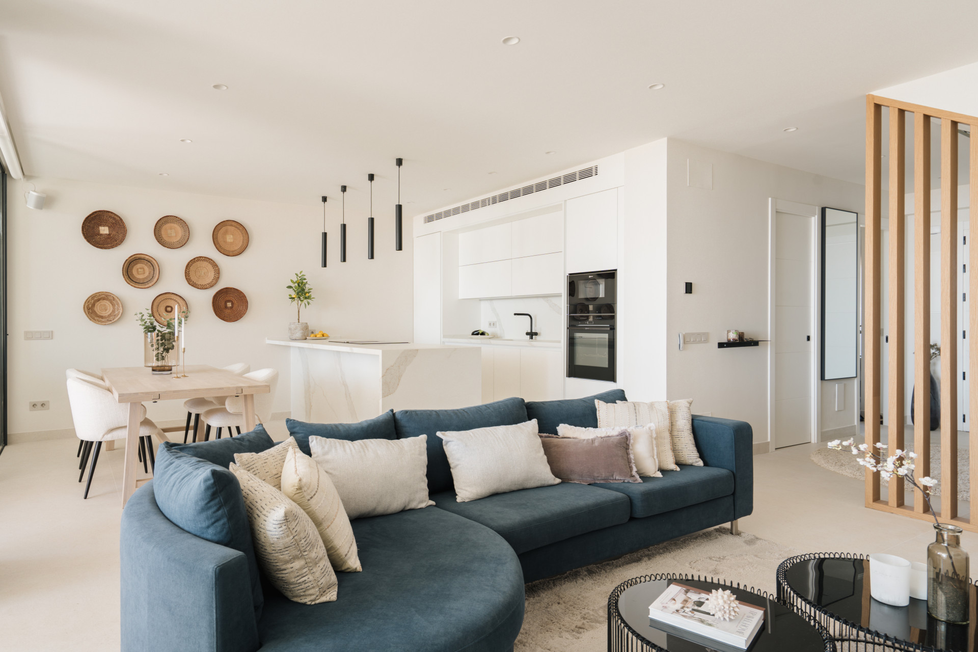 Renovated open-plan living room, dining area and white kitchen in the Les Belvederes duplex penthouse