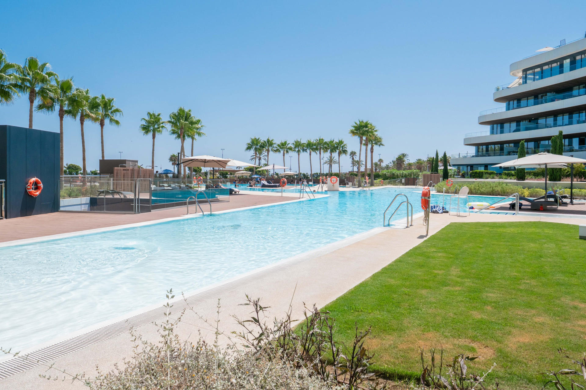 Communal outdoor swimming pools and palm-lined gardens at Residencial Nereidas.